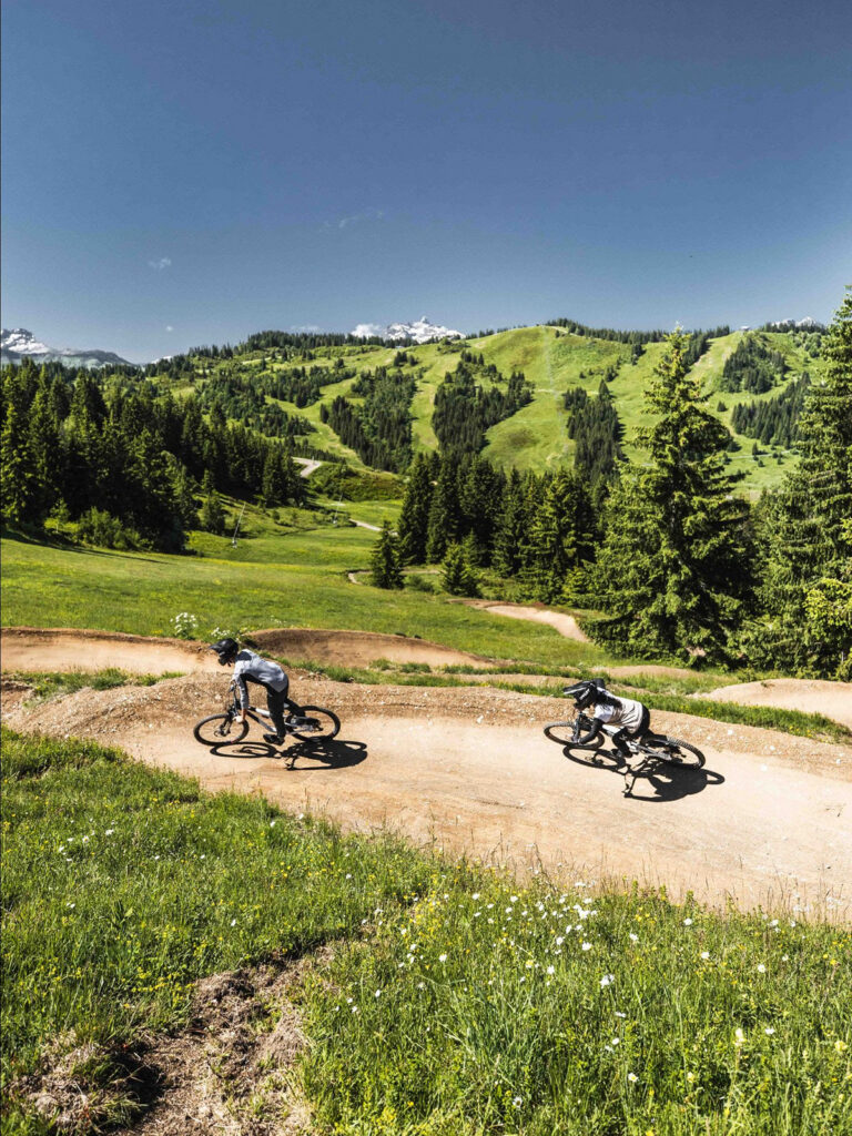 two mountain bikers going down track in les gets morzine summer