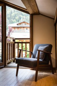 Armchair beside the bedroom balcony at Chalet Coffy with views towards the surrounding mountains