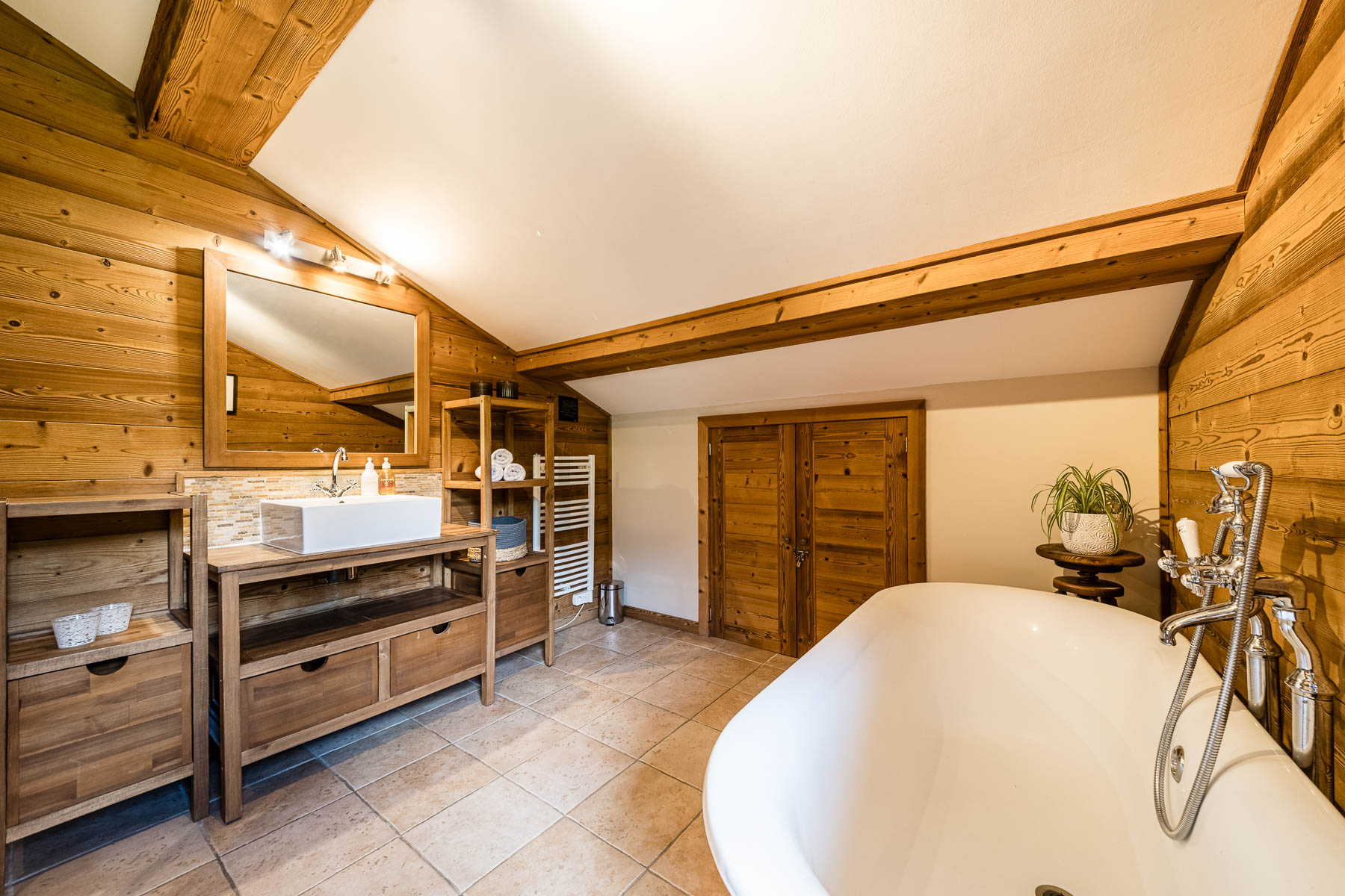 Alpine-style bathroom at Chalet Coffy in Morzine with a freestanding bath and wooden interiors
