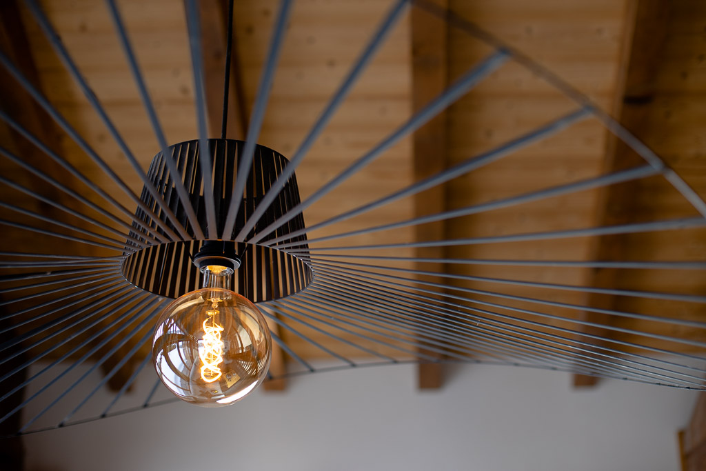 Feature pendant light beneath the exposed wooden ceiling at Chalet Coffy in Morzine