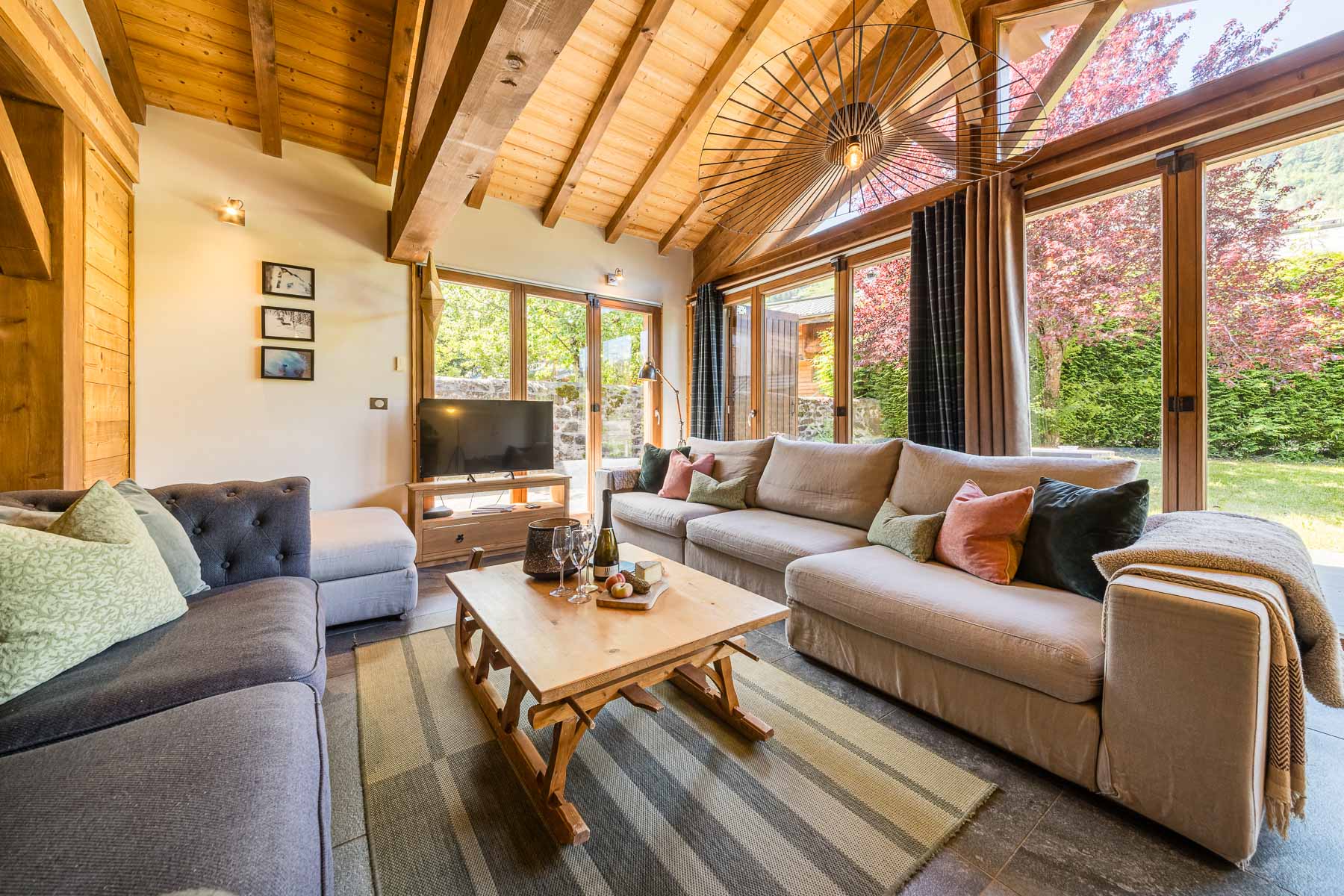 Spacious Chalet Coffy living room with exposed timber beams and garden views