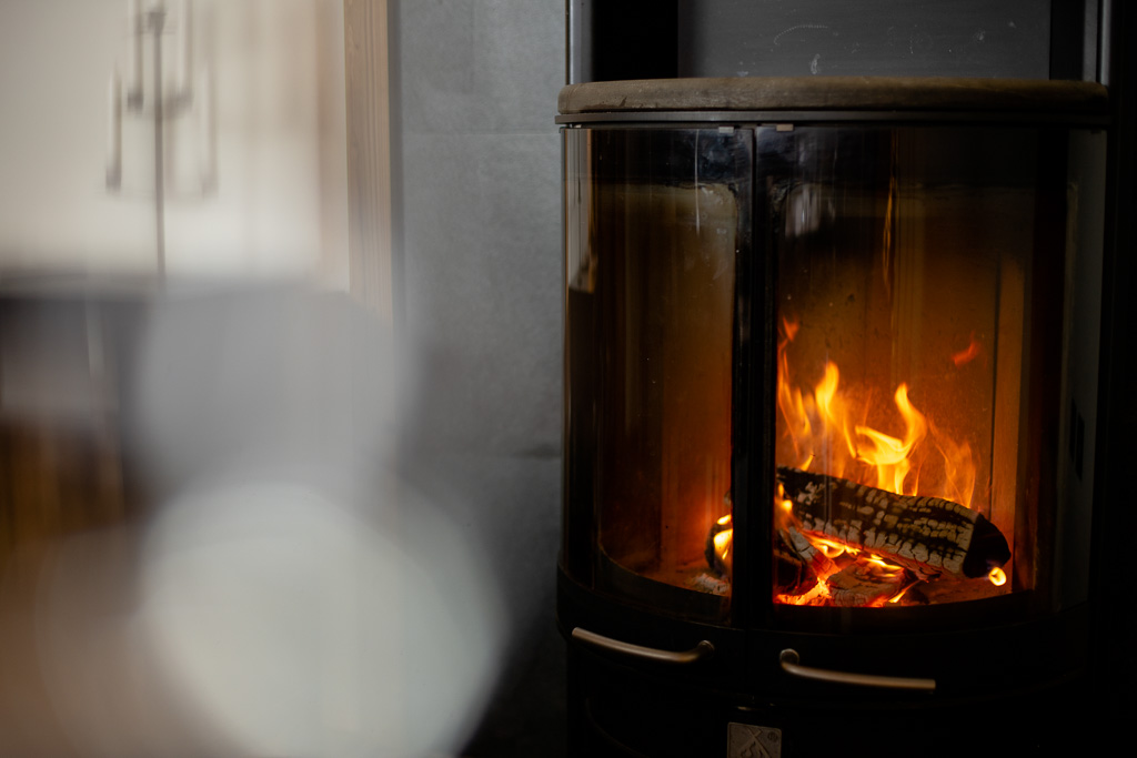 Wood-burning stove with a glowing log fire at Chalet Coffy in Morzine