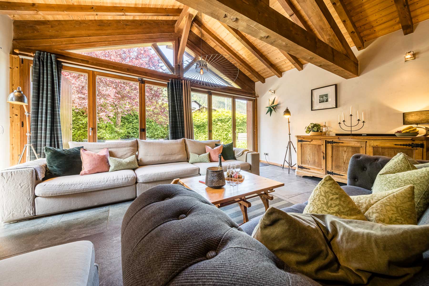 Chalet Coffy lounge with large windows, comfortable sofas and exposed wooden beams