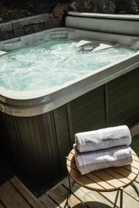Outdoor hot tub and terrace with towels at Chalet Floralies