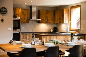 Dining table and rustic kitchen at Chalet La Grange