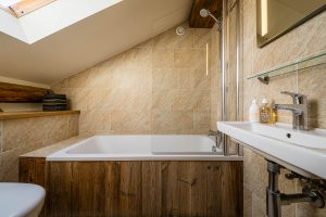 Loft bathroom with bath and shower at Chalet La Grange