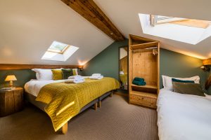 Loft family bedroom arranged with twin beds at Chalet La Grange