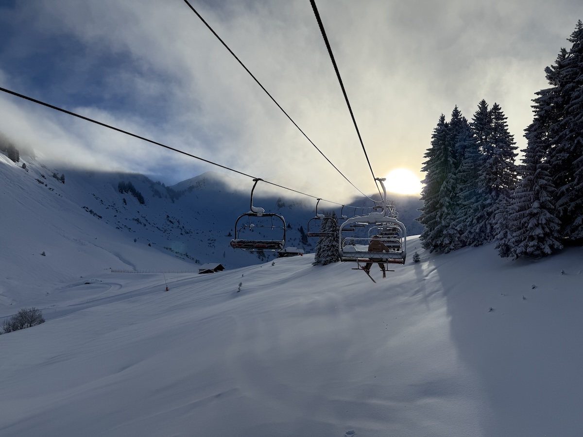 Skier sitting on a ski lift on a sunny day in Morzine in the Portes du Soleil